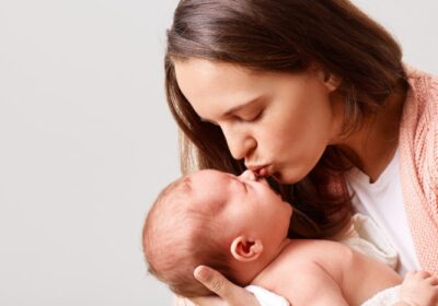 closeup-portrait-winsome-woman-kissing-her-newborn-baby-with-closed-eyes